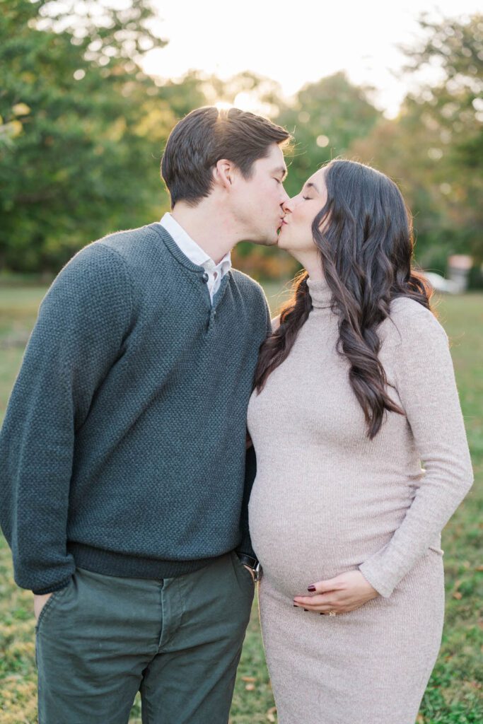 Parents-to-be kiss during their maternity session at Cherokee Park