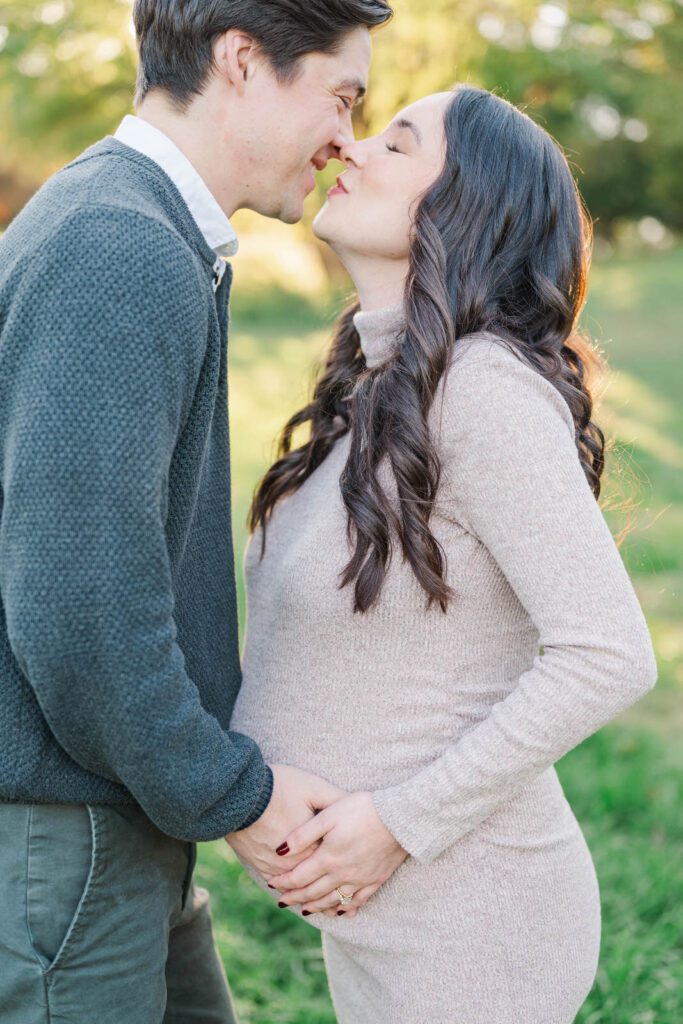 Parents-to-be kiss during their Cherokee Park maternity session