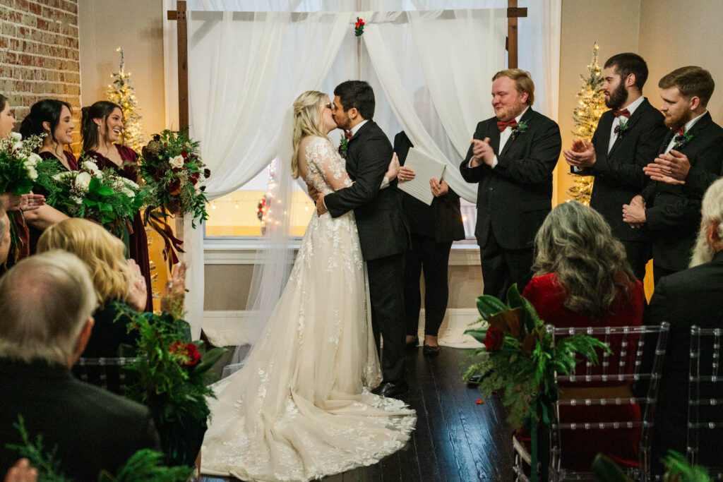 Bride and groom share their first kiss at the wedding ceremony