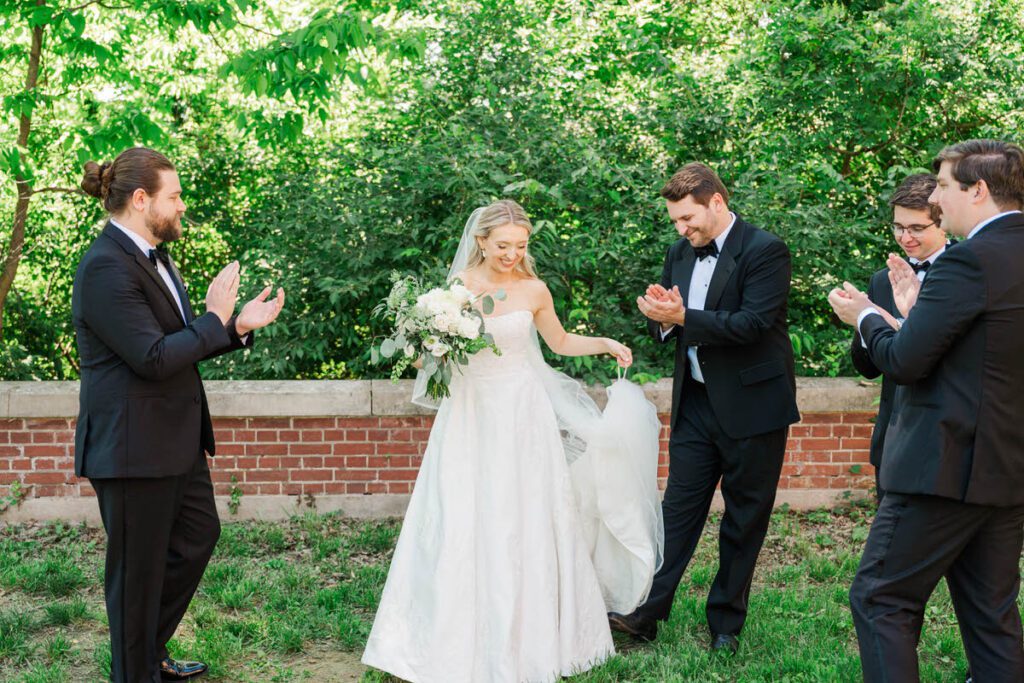 Groomsmen clap for the bride at a Gardencourt wedding day