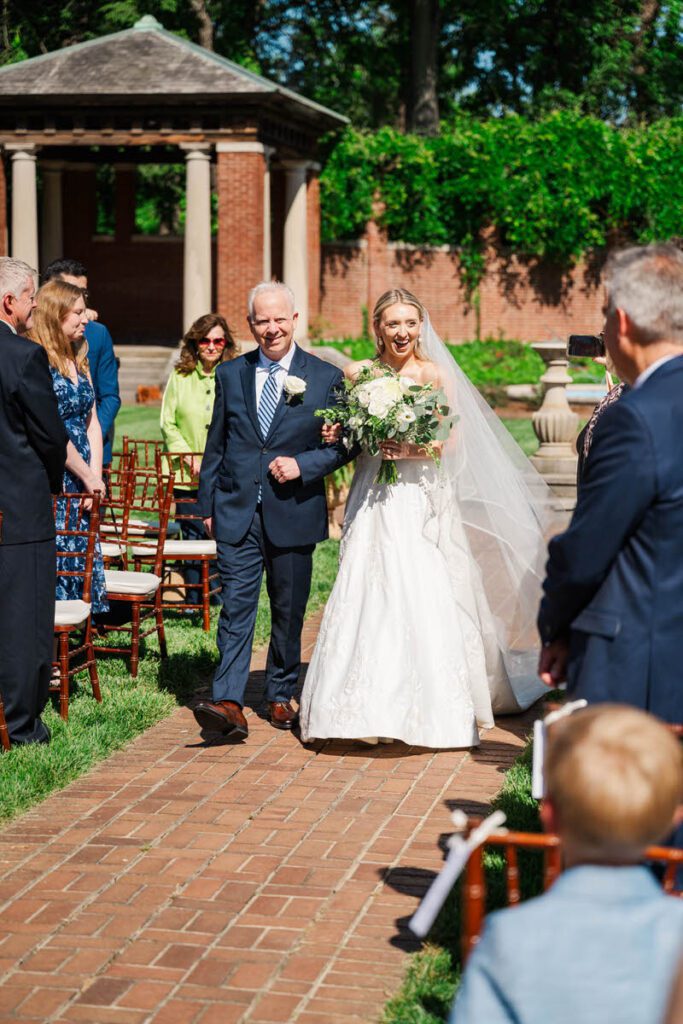 Bride walks down the aisle with her father at a Gardencourt wedding day