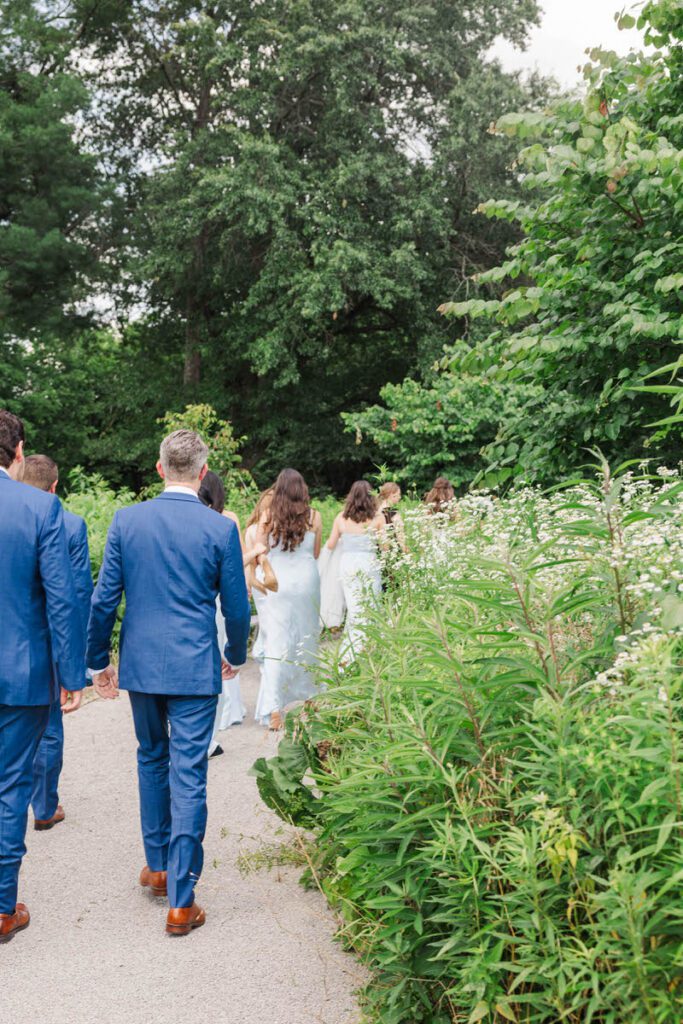 Bridal party walking down a path of wildflowers at a Gheens Foundation Lodge wedding