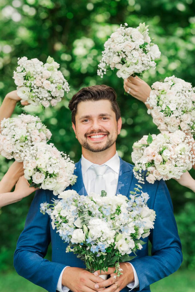 Groom surrounded by flowers at a Gheens Foundation Lodge wedding