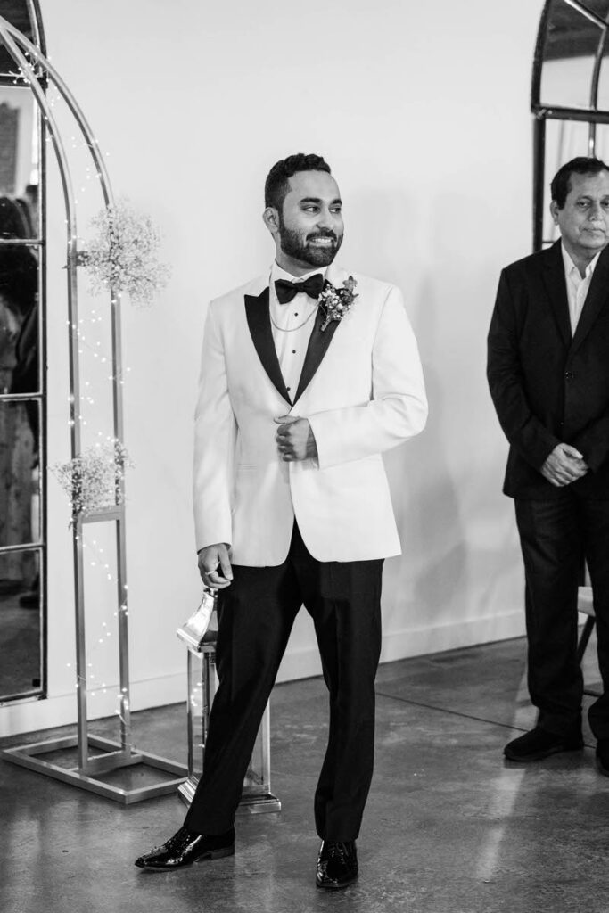 Groom smiles as he wait for his bride to walk down the aisle on his wedding day at Mellwood Art Center