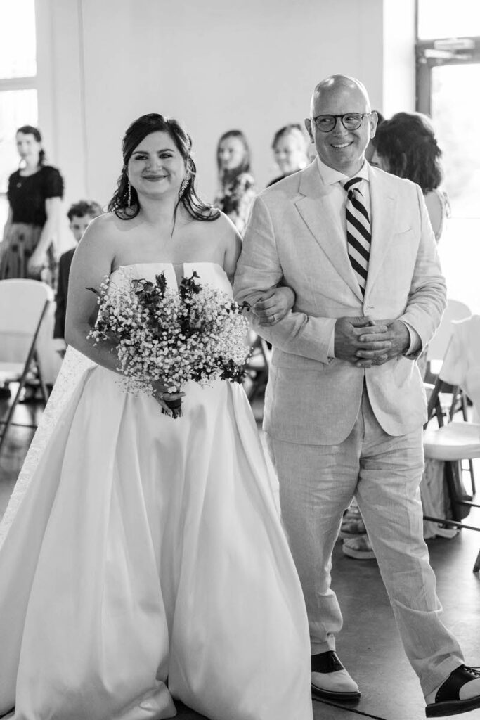 Bride and her father walk down the aisle on her wedding day at Mellwood Art Center
