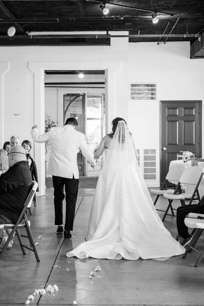Bride and groom dance down the aisle after getting married on their wedding day at Mellwood Art Center in Louisville, KY