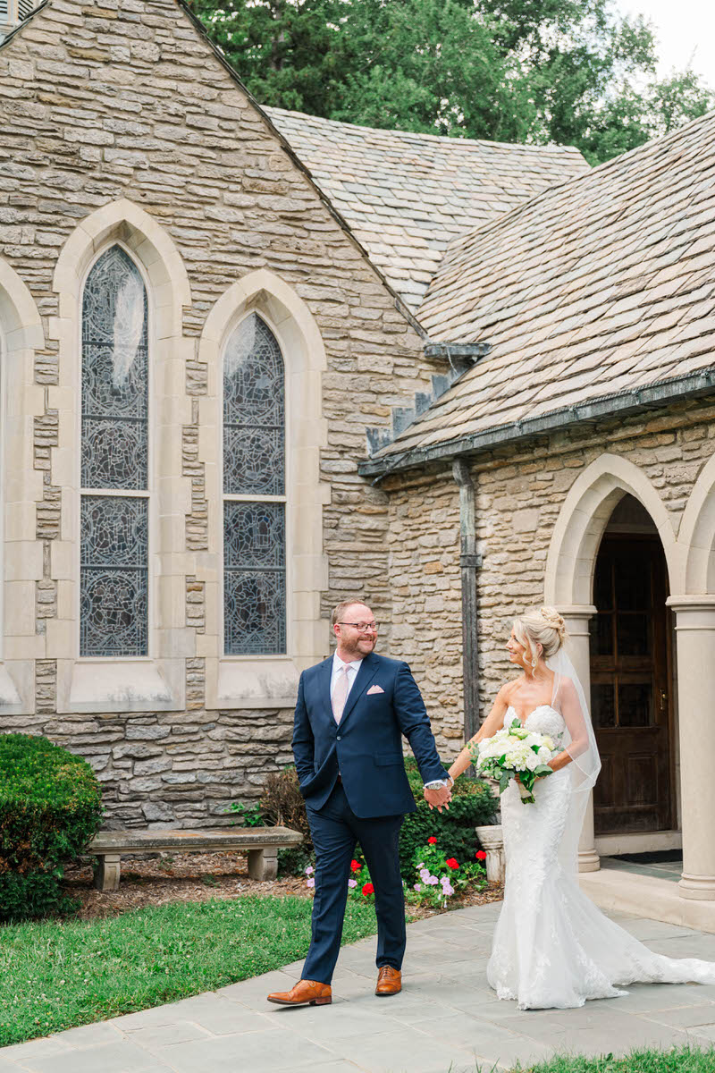Bride and groom walk hand in hand in front of Duncan Memorial Chapel before their wedding ceremony