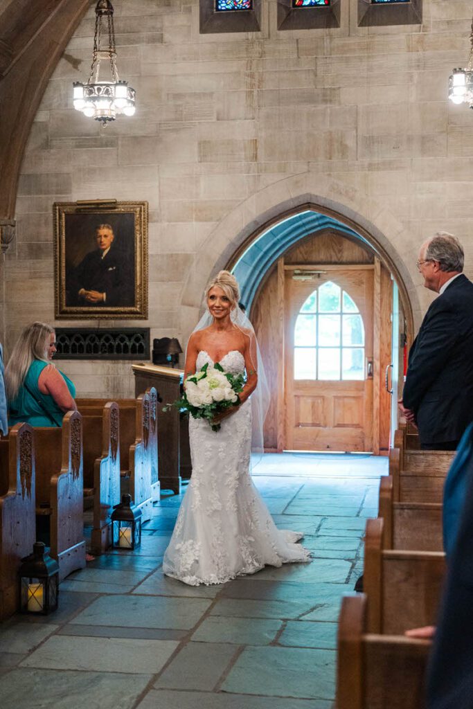 Bride walks down the aisle during a wedding ceremony at Duncan Memorial Chapel
