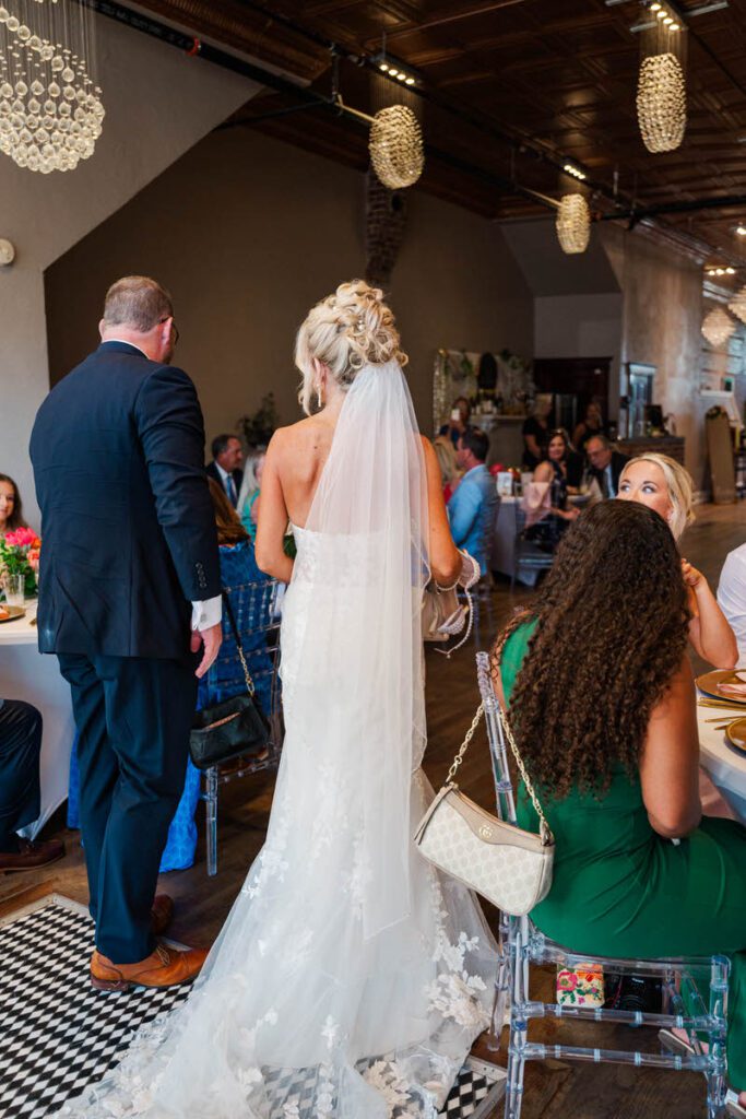 Bride and groom walk into their wedding reception at The Gatewood in La Grange