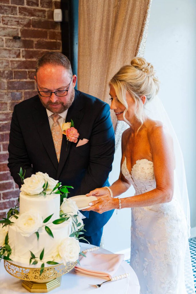Bride and groom cut the cake at their wedding reception at The Gatewood in La Grange