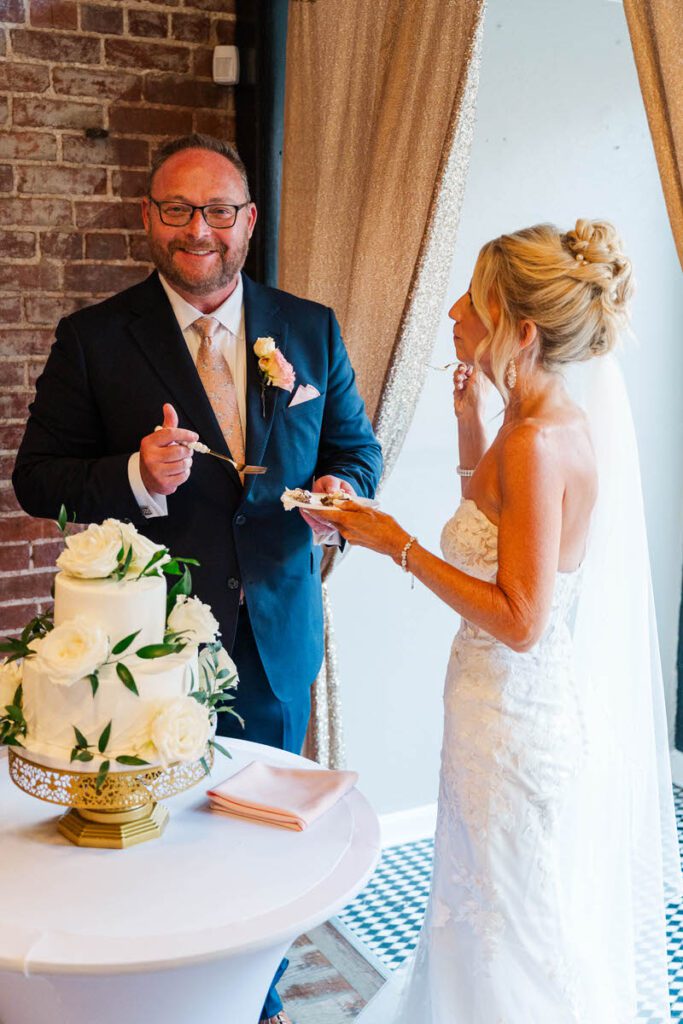 Bride and groom cut the cake at their wedding reception at The Gatewood in La Grange