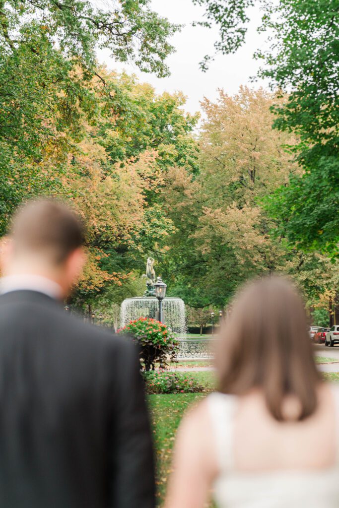 Couple walks in front of the fountain at Saint James Court for their engagement session.