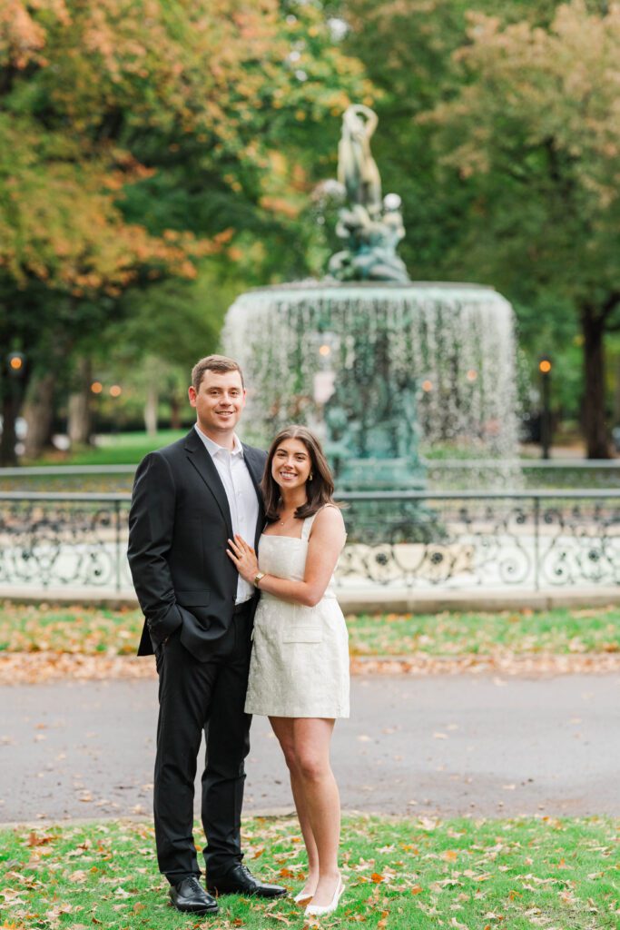 Couple stands in front of the fountain at Saint James Court for their engagement session.