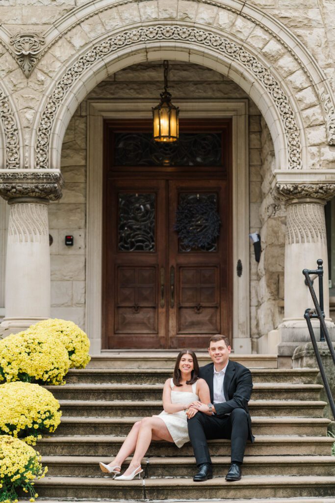 Engaged couple sits together on stairs at Saint James Court in Louisville, Ky