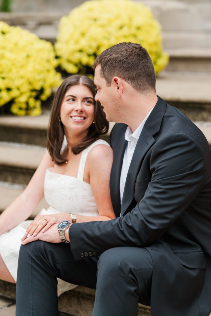 Engaged couple sits together on stairs at Saint James Court in Louisville, Ky