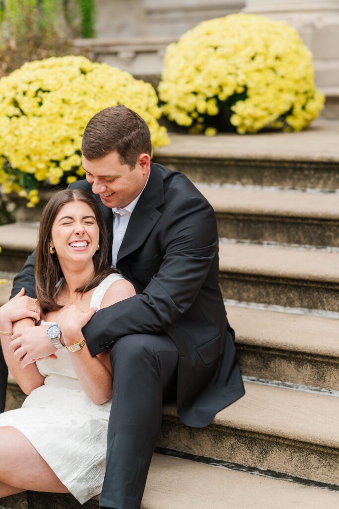 Engaged couple sits together on stairs at Saint James Court in Louisville, Ky