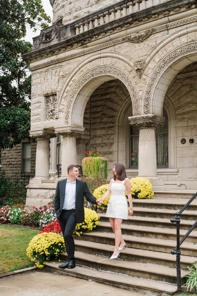 Engaged couple walks down stairs at Saint James Court in Louisville, Ky
