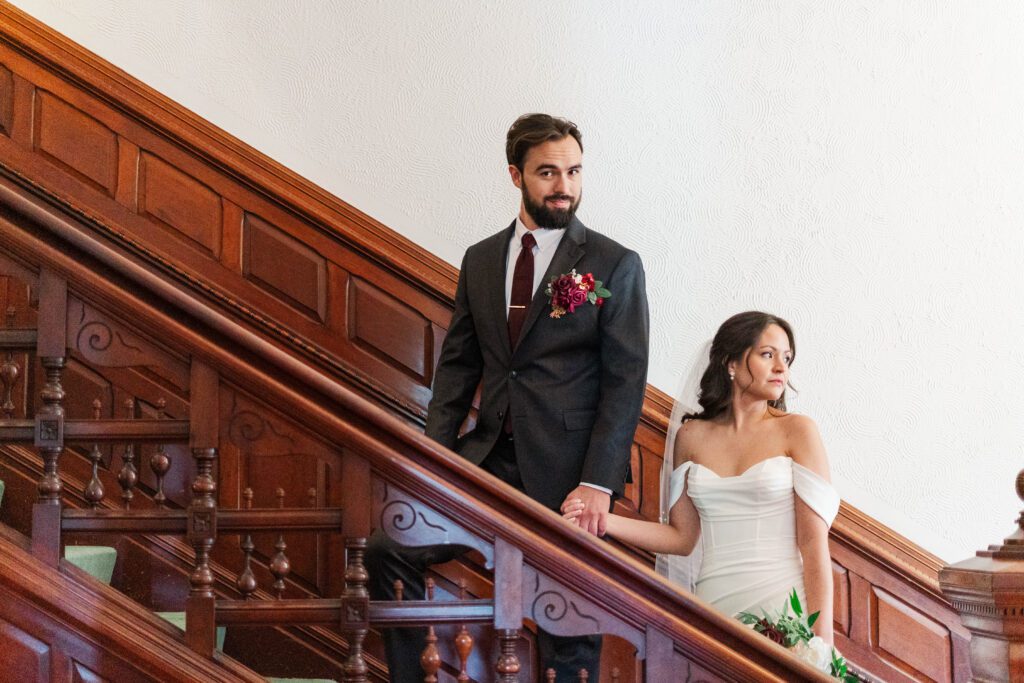 Bride and groom walk up the stairs inside The Bell House on their wedding day