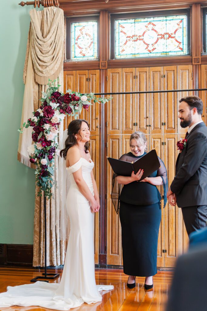 Bride and groom laugh during their wedding ceremony at The Bell House in Lexington