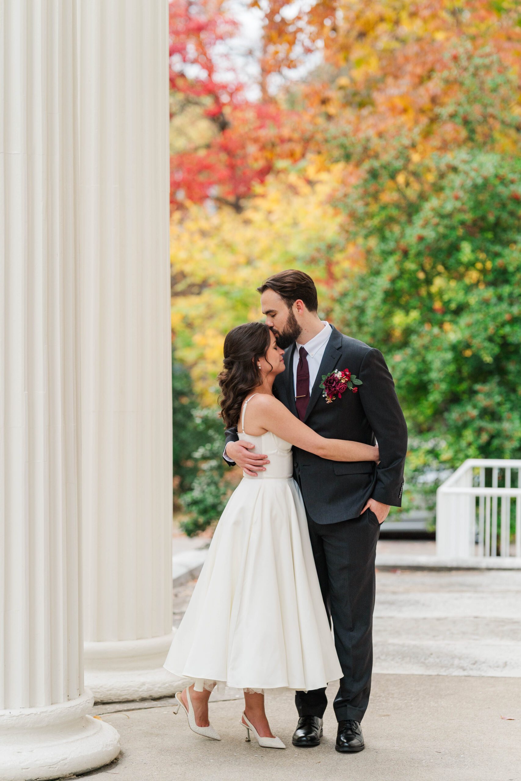 Bride and groom stand on the front porch of the Bell House in Lexington, KY on their wedding day