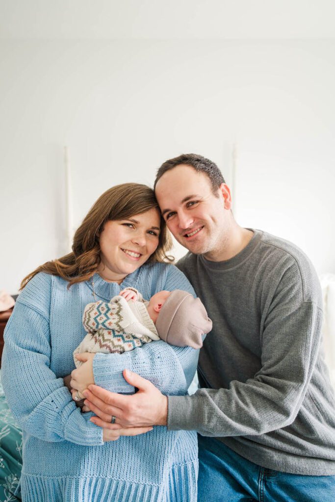 A new mom and dad pose for a photo with baby boy.