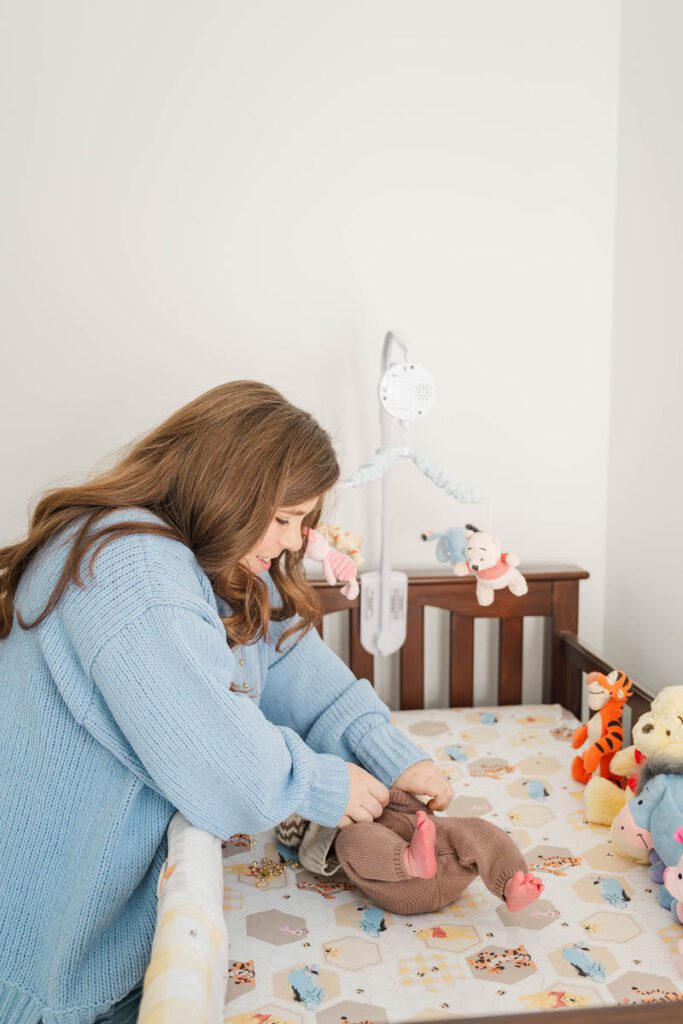 Mom changes baby boy's clothes.