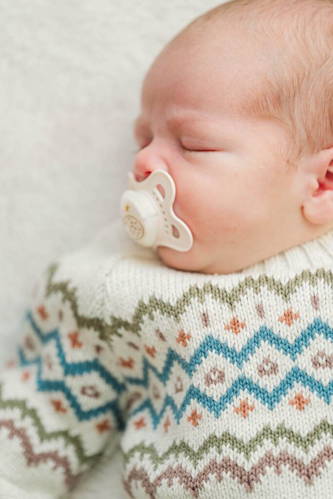 A newborn baby boy sleeps soundly during his in home newborn session.