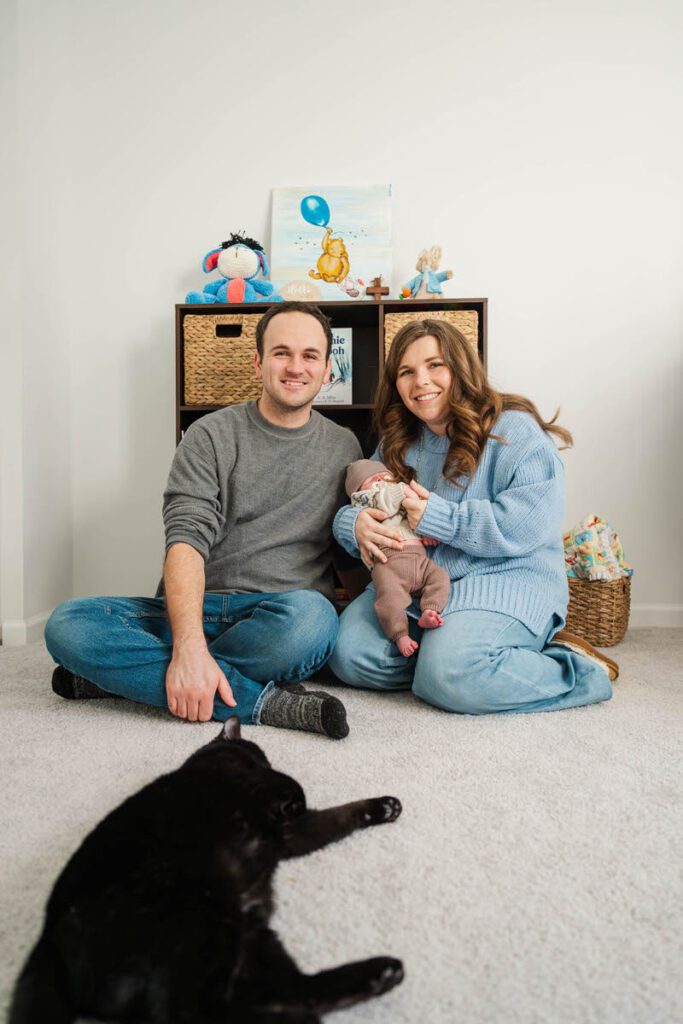 A family sits in baby's nursery during their in home newborn session.
