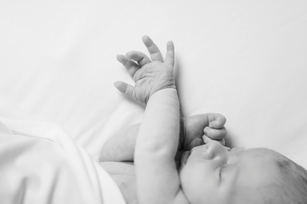 A black and white image of a newborn baby. Louisville In Home Newborn Session Photos by Michelle Bordenkircher Photography