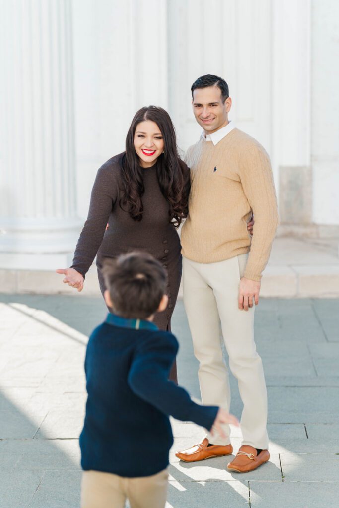 A boy runs toward his parents during their winter family session at the Louisville Water Tower Photos by Michelle Bordenkircher Photography