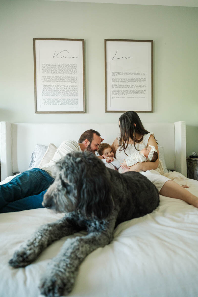 A family snuggles on the bed during their Louisville In-Home Family Photography Session. Photos by Michelle Bordenkircher Photography.